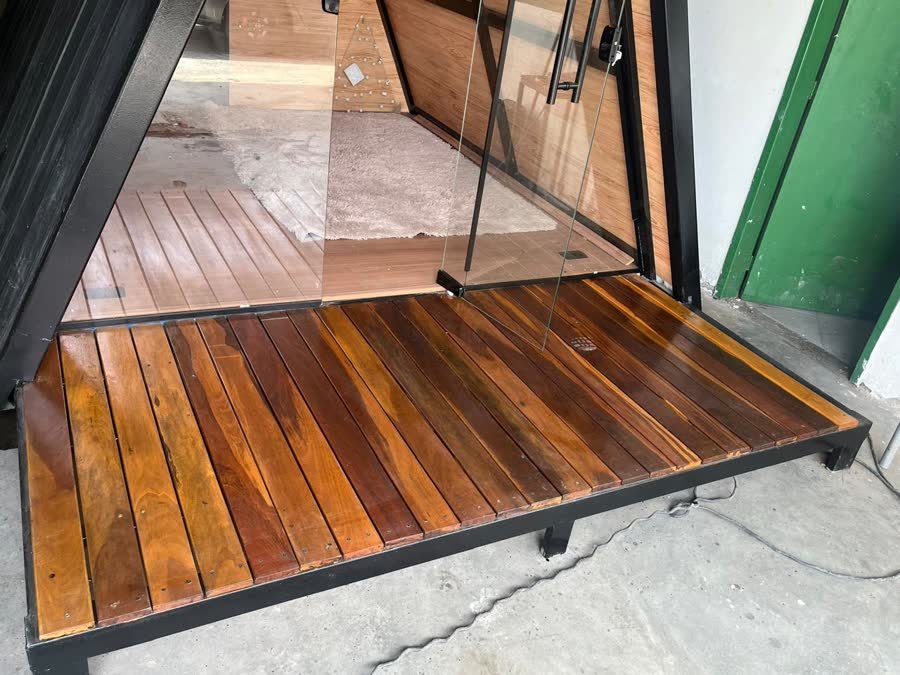 Detalhe do deck em madeira de lei envernizada com estrutura em metalon preto