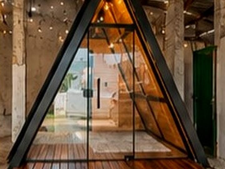 Chalé A-frame iluminado com varal de lâmpadas sobre o deck